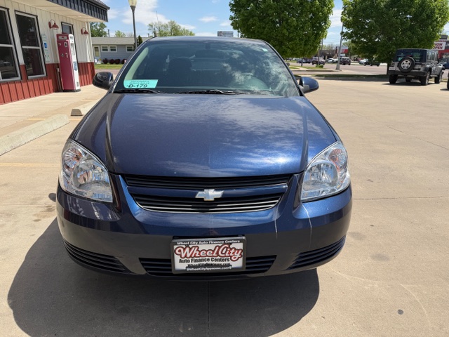 Front view of a blue Chevrolet sedan parked in a dealership lot with a Wheel City Auto Finance Centers license plate frame visible on the bumper.