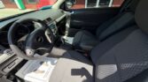 Interior of a Chevrolet car showing the driver and front passenger seats, steering wheel, center console, and dashboard.