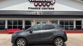 Gray compact SUV parked in front of Wheel City Auto Finance Centers storefront.