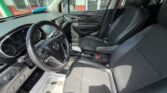 Driver's-side view of a modern car interior with black leather seats, steering wheel, and center console visible from the front passenger seat.