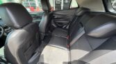 Back seat area of a car with three black leather seats, headrests, and visible seat belts, sunlit through windows.