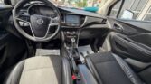 Interior of a Buick sedan with black leather seats, steering wheel, center touchscreen, and gear shift.