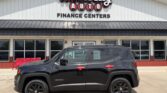 Black Jeep Renegade SUV parked in front of Wheel City Auto Finance Centers storefront; red bench to the left.