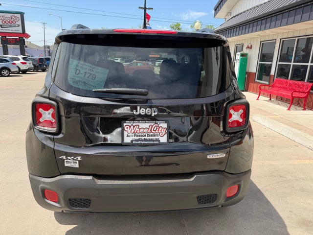 Rear view of a black Jeep SUV in a dealership lot; Jeep emblem, 4x4 badge, and Wheel City license plate frame visible.