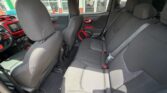 Rear and front interior of a car with gray fabric seats and red door/trims visible on panels.