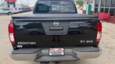Rear view of a black Nissan Frontier SV 4x4 pickup on a dealership lot, with Wheel City license plate frame on the bumper.