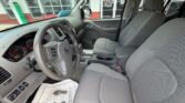Interior of a gray pickup truck showing the steering wheel, dashboard gauges, center console, gear shifter, and front seats viewed from the driver’s side.
