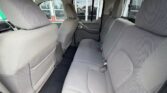 Back seat of a gray fabric SUV with three headrests and seat belts, seen from the rear passenger area.