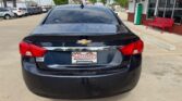 Black Chevrolet sedan parked in a dealership lot, rear view with Wheel City Auto Finance Centers plate frame and red tail lights.