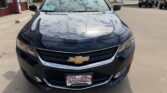 Front view of a black Chevrolet sedan in a parking lot, chrome grille with gold bowtie emblem and a dealership plate reading Wheel City Auto Finance Centers