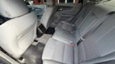 Interior of a gray sedan showing the rear seats with three headrests and a center seat belt, gray fabric upholstery, and floor mats visible.