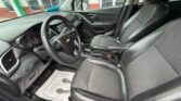 Front interior of a Chevrolet SUV showing black leather seats, steering wheel with Chevrolet emblem, dashboard, and center console.