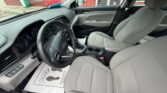 Front interior of a gray Hyundai sedan with cloth seats, steering wheel, dashboard, and center console visible from the passenger side