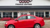 Red sedan parked in front of Wheel City Auto Finance Centers storefront.