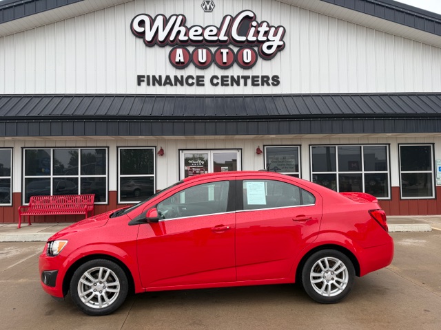 Red sedan parked in front of Wheel City Auto Finance Centers storefront.