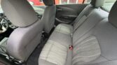 Interior of a compact car showing gray rear seats and front seats, with seat belts and door panels visible.