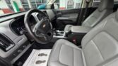 Front interior of a Chevrolet SUV with gray leather seats, steering wheel, and center console.