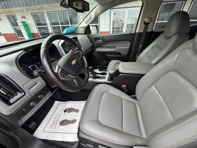 Front interior of a Chevrolet SUV with gray leather seats, steering wheel, and center console.