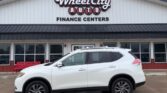 White SUV parked in front of Wheel City Auto Finance Centers storefront, dealership signage visible.