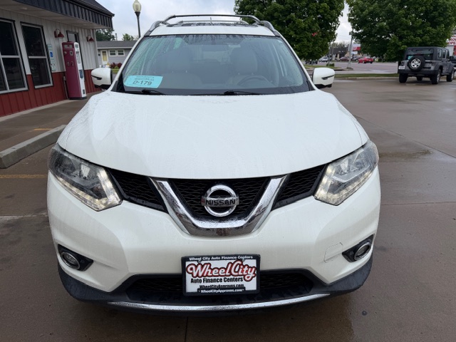 Front view of a white Nissan SUV parked in a dealership lot, with a Wheels City license plate frame on the front bumper.