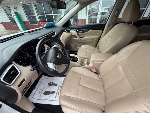 Front interior of a beige leather SUV showing driver's seat, steering wheel, and center console.