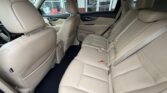 Beige leather car interior showing a three-seat rear bench with visible seat belts and front seats in view.