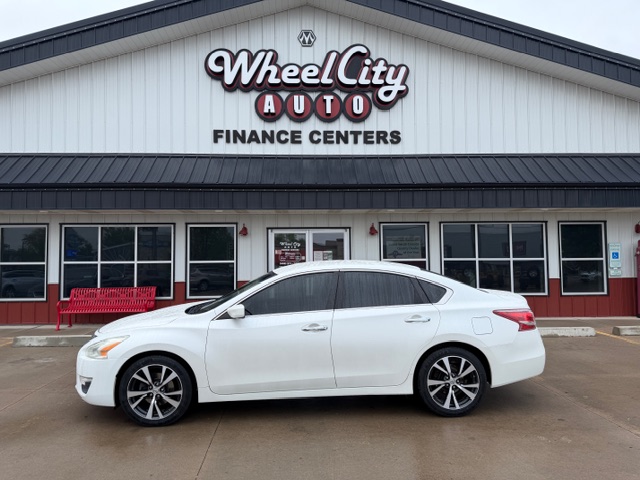 White sedan parked in front of the Wheel City Auto Finance Centers storefront.