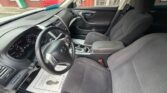 Interior view of a gray fabric-seat car from the driver’s side, showing the steering wheel, dashboard, center console, and front seats in a parked vehicle