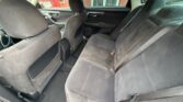 Rear interior of a dark gray fabric sedan, showing the back seats and front seats from the left rear door.