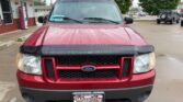 Front view of a red Ford SUV parked in a dealership lot on a rainy day, with a black hood deflector and a Wheel City Auto Finance Centers plate.