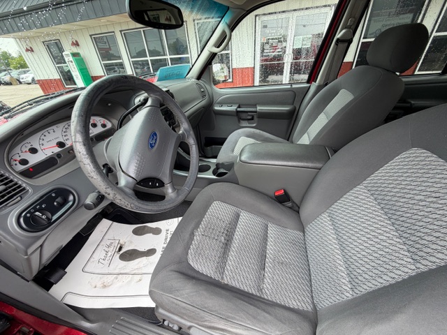 Front interior of a gray Ford pickup, showing the steering wheel, dashboard, center console, and two front seats from the driver's side.