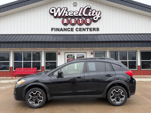 Black compact crossover SUV parked in front of Wheel City Auto Finance Centers storefront.
