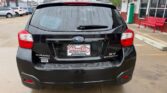 Rear view of a black Subaru XV Crosstrek at a car dealership lot, with Wheel City Auto Finance Centers license plate frame and a wet rear window.