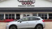 Silver SUV parked in front of Wheel City Auto Finance Centers storefront.