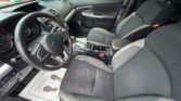 Front interior of a Subaru SUV: driver and passenger seats, steering wheel with badge, and center console; floor mat reads 'Thank you'.