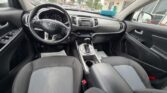 Interior of a Kia car showing the driver's seat, steering wheel, center console with gear shift, and front passenger seat available for the next ride or test drive.