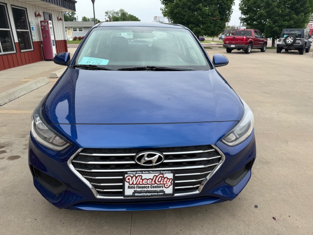 Front view of a blue Hyundai sedan parked in a dealership lot, with Wheel City Auto Finance Centers license plate frame on the front bumper.