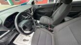 Front interior of a Hyundai car showing the steering wheel, dashboard, center console, and gray fabric seats.