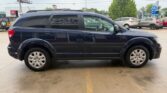Side view of a dark-blue SUV parked in a parking lot with other cars in the background.