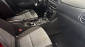 Front interior of a car: driver and passenger seats, center console with gear shifter and touchscreen display.