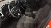 Interior of a modern car from the driver’s side, showing the steering wheel, dashboard, center console, and front passenger seat