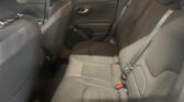 Back seat area of a dark gray car interior with three seat cushions, visible seat belts, and a door panel on the right side, photographed from a rear passenger vantage point.