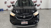 Front view of a black Buick SUV in a showroom with Wheel City Auto Finance Centers banners in the background.