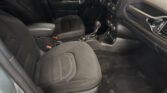 Front interior of a dark car: driver and passenger seats with center console and gear shifter visible on the floor left of the passenger seat inside a black cabin.