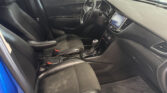 Driver’s area of a black leather car interior: steering wheel, center touchscreen, and gear shifter visible.