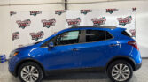 Blue SUV shown in a showroom with a repeating Wheel City Auto Finance Centers banner in the background, side profile visible.