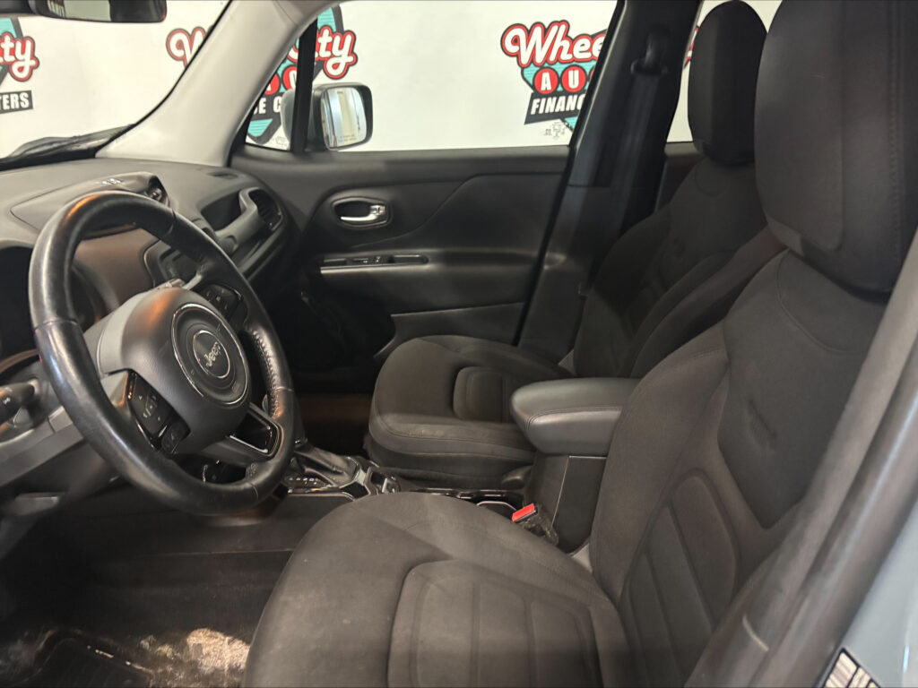 Inside a black car showing the front seats, steering wheel, and center console from the passenger side view