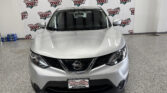 Front view of a silver Nissan SUV indoors, with a Wheel City Auto Finance Centers backdrop behind it.