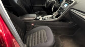 Front interior of a red car showing black leather seats, center console, and dashboard with gear shifter and steering wheel visible.