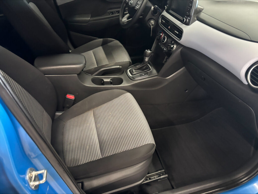 Front interior of a car with fabric seats, center console, gear shifter, and dashboard touchscreen.